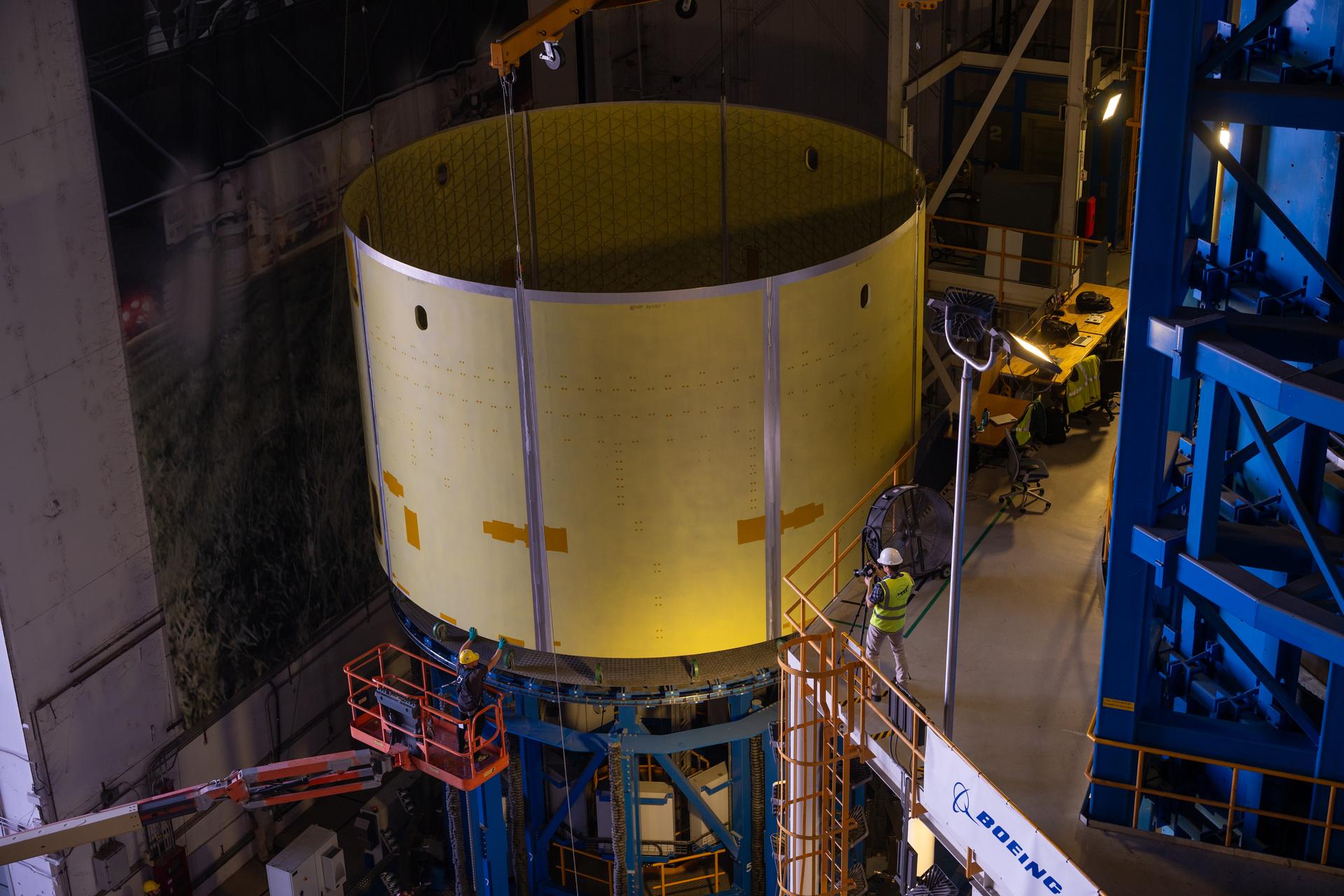 Teams at Michoud Assembly Facility in New Orleans load the engine section barrel into the vertical assembly center on Aug. 5, 2026. The engine section will be used on the SLS (Space Launch System) rocket’s core stage for the agency’s Artemis V mission. On the vertical assembly center tooling, teams will mate the flight hardware to a ring, which will serve as an attachment point for the liquid hydrogen tank later in the production process. The engine section is one of five major elements that make up the 212-foot-tall SLS rocket stage; and houses various avionic systems, the engine thrust structure, and four RS-25 engines. The core stage produces more than two million pounds of thrust to help launch NASA’s Orion spacecraft, astronauts, and supplies beyond Earth’s orbit and to the lunar surface for Artemis.